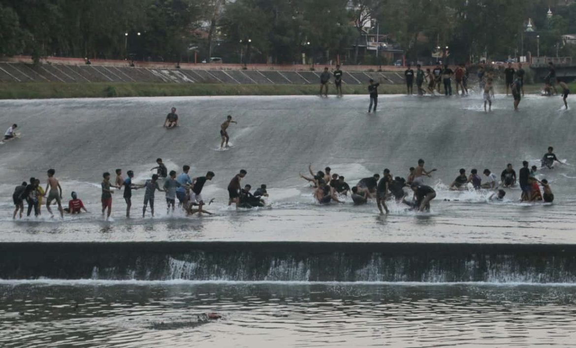 Pemandangan banyaknya anak-anak dan remaja yang main seluncuran di pintu air bendungan Pleret Banjirkanal Barat (BKB) Kota Semarang, baru-baru ini.