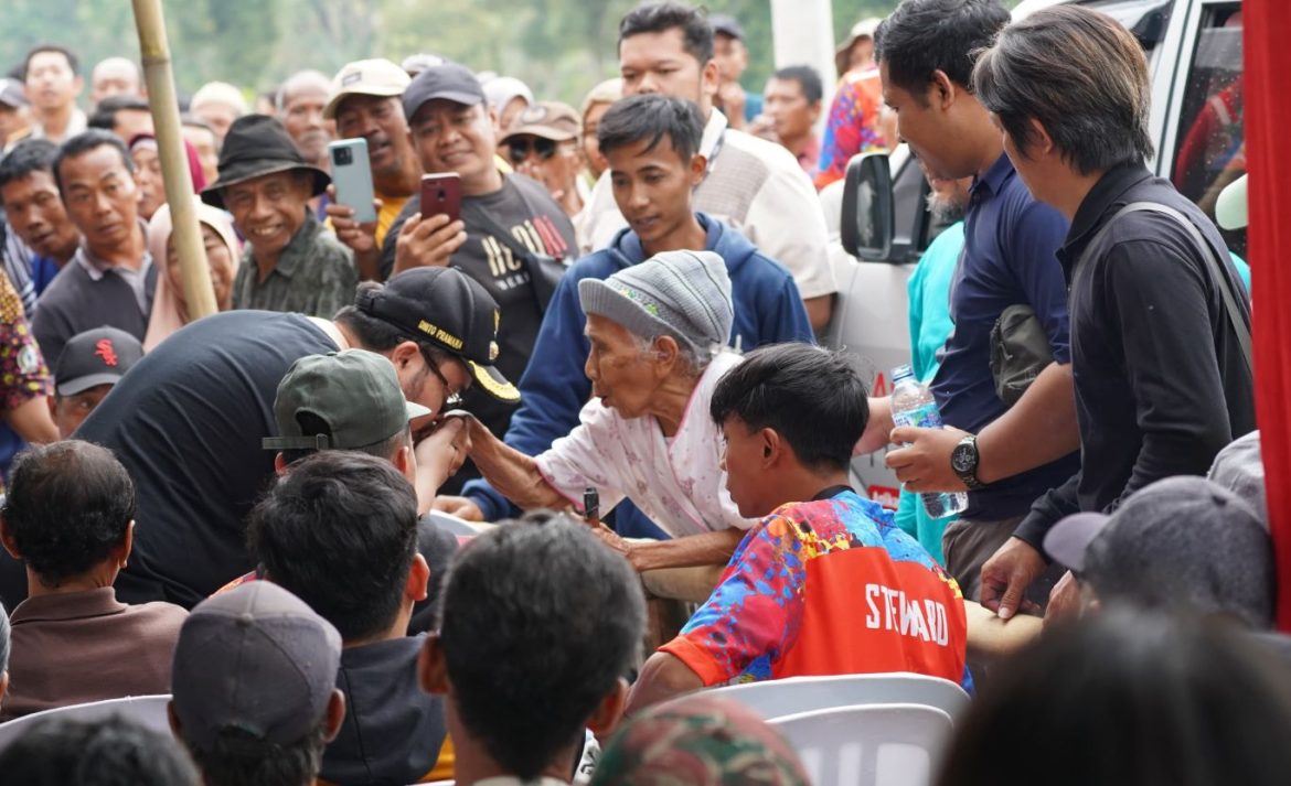 Bupati Kediri Mas Dhito, menyalami dan mencium tangan seorang nenek, di sela acara penyerahan sertifikat tanah elektronik melalui program PTSL bagi warga Desa Kampungbaru, Kecamatan Kepung.