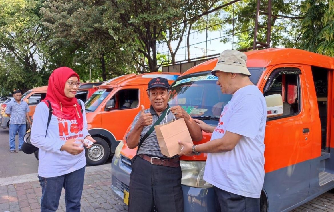 Ketua PN Semarang Judi Prasetya (kanan) membagikan snack dalam kegiatan kampanye antikorupsi di tempat publik.