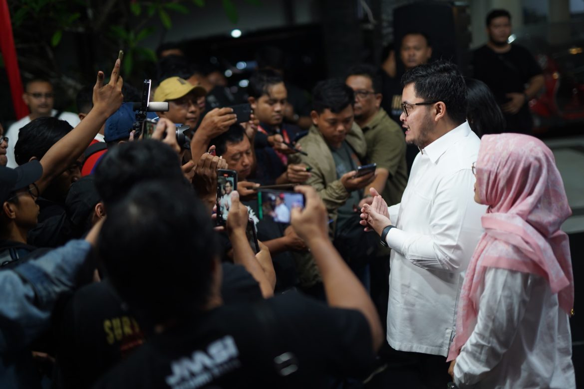 Calon Bupati Kediri petahana Hanindhito Himawan Pramana merangkul pendukung Denny Widyanarko setelah menang quick count.