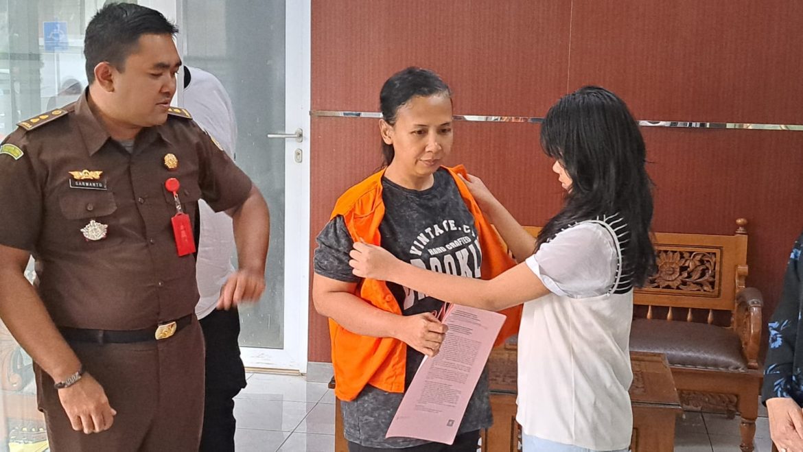 Korban KDRT (kanan) membantu melepas baju tahanan tersangka KDRT yang merupakan ibu kandungnya.